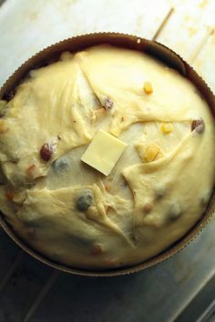 a pan filled with food sitting on top of a wooden table next to a knife