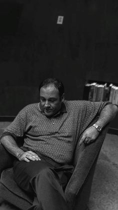 a black and white photo of a man sitting in a chair