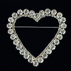 a heart shaped brooch with crystal stones