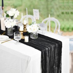 the table is set with white flowers and candles