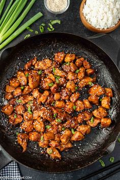 chicken in a skillet with rice and green onions