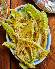 lettuce wedges with seasoning on top in a bowl next to a fork and spoon