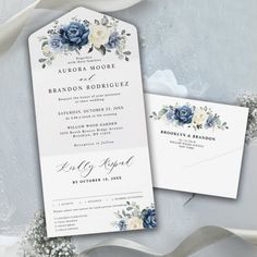 wedding stationery with blue flowers and white ribbon on the side, along with two matching envelopes