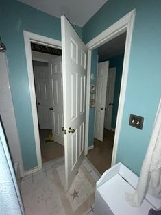 an empty bathroom with blue walls and white fixtures