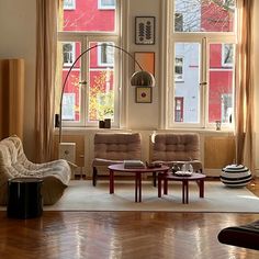 a living room filled with furniture and lots of window sill windows covered in curtains