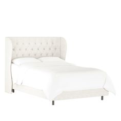 the bed is made up with white linens and has a tufted headboard