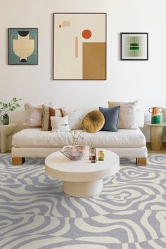 a living room filled with furniture and pictures on the wall above it's coffee table