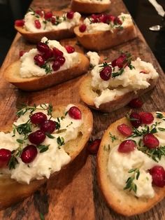 bread topped with whipped cream and cranberries on a cutting board