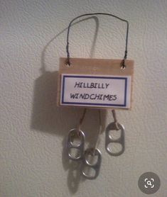 a sign hanging on the wall that says hillbilly wind chimes with two pairs of scissors attached to it