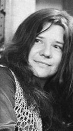 an old black and white photo of a woman with long hair smiling at the camera