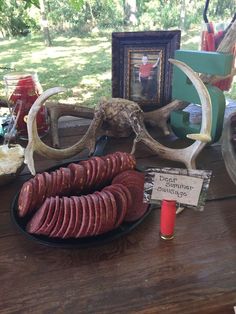 an assortment of sausages on a table with antlers