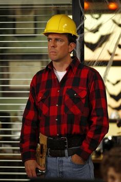 a man wearing a hard hat and plaid shirt