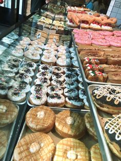 a display case filled with lots of different types of doughnuts and pastries