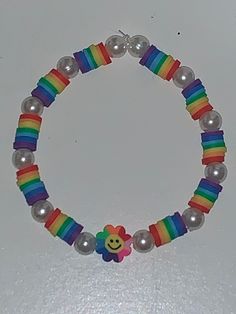 a colorful bracelet with beads and a smiley face on the bead stranding around it