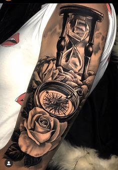 a man with a clock and roses tattoo on his arm is holding an hourglass