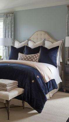 a bedroom with blue and white bedding, pillows and lamps on the nightstands