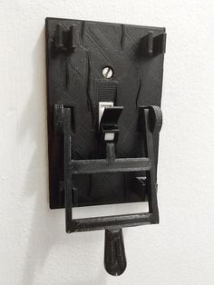 a wall mounted light switch on the side of a white wall with a black frame