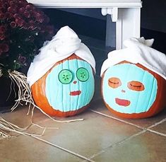 two pumpkins with faces painted on them