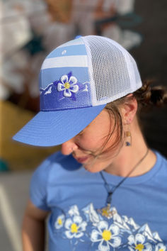 Structured trucker hat with striped design screenprinted on front panels. Colorado's state flower - the Columbine - featured on front. Things To Come