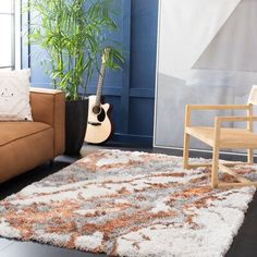 a living room with a couch, chair and guitar on the floor in front of a blue wall