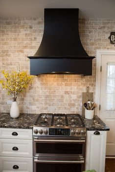 a stove top oven sitting inside of a kitchen next to a wall mounted range hood