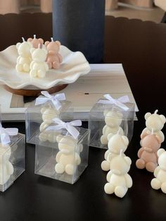 small clear boxes with teddy bears in them sitting on a table next to a cake