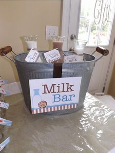 a metal bucket filled with milk on top of a table