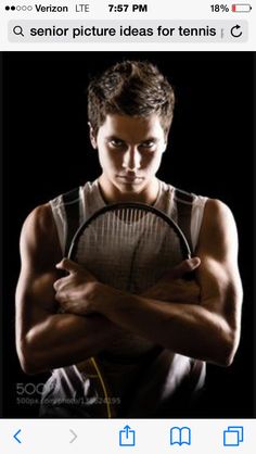 a man holding a tennis racquet in his hands and posing for the camera