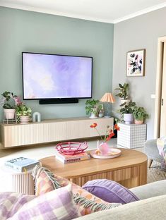 a living room filled with furniture and a flat screen tv mounted to the side of a wall