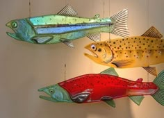 three different colored fish hanging from the ceiling