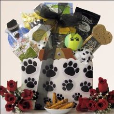 a dog themed gift basket with red roses and treats in it's centerpiece