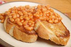 a plate topped with bread covered in baked beans