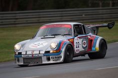 an old race car driving down the road