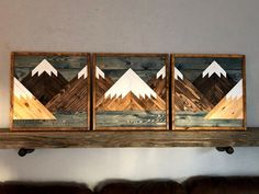 three pieces of wood sitting on top of a wooden shelf next to a brown couch