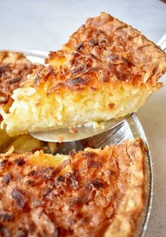 a piece of quiche is being lifted from a pie pan by a spatula