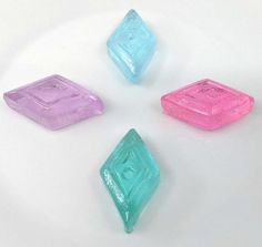 four different colored candies sitting on top of a white plate