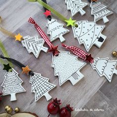 decorated christmas tree cookies sitting on top of a wooden table next to ribbons and decorations