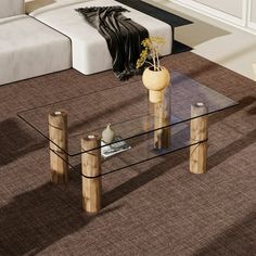 a glass coffee table with wooden legs on carpeted flooring in front of a white couch