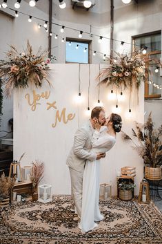 a bride and groom kissing in front of a sign that says, you're me