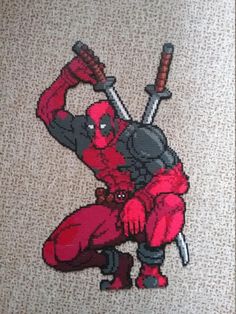 the deadpool is holding two swords in his hands