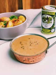 a bowl of food next to a can of soup