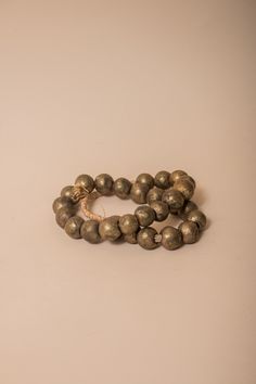 These brass African beads are beautifully textured, each individual bead unique in shape and finish for a final look that feels one-of-a-kind and natural. Perfect for layering on a vase, an open book, a bowl, or styling on a shelf. All Sales Final Free Shipping Brass Beaded Bracelets With Round Beads, Rustic Large Beads For Gifts, Gold Bracelets With Wooden Beads For Healing, Traditional Gold Beaded Bracelets With Wooden Beads, Large Bronze Round Beads, Gold Beaded Bracelets With Wooden Beads, Unique Gold Beaded Bracelet With Wooden Beads, Unique Gold Beaded Bracelets With Wooden Beads, Artisan Gold Bracelets With Wooden Beads