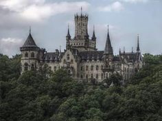 an old castle sitting on top of a lush green hillside