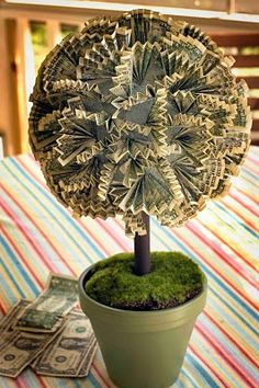 a potted plant with money in it on top of a striped cloth tablecloth