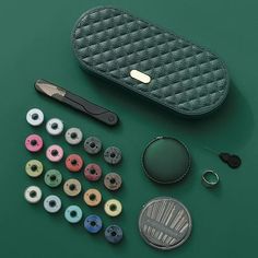 an assortment of sewing supplies on a green surface with scissors, buttons and other items