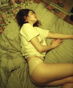 a woman laying in bed with her legs crossed