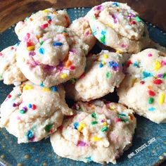 a blue plate topped with white frosted cookies covered in sprinkles