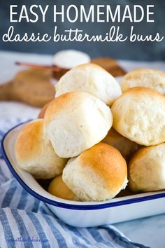 a bowl filled with rolls on top of a blue and white table cloth