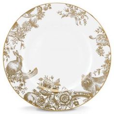 a white and gold plate with an image of animals on it, surrounded by flowers