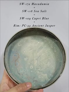 a hand is holding a bowl with blue paint on it and the words, sw - 11 sea salt